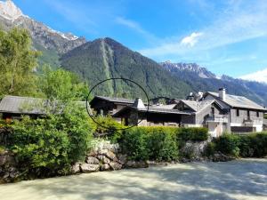 une maison à côté d'une rivière avec des montagnes en arrière-plan dans l'établissement Chalet Claudia by Brennus Chamonix, à Chamonix-Mont-Blanc