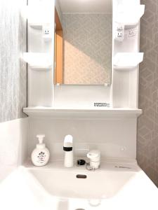 a bathroom with a white sink with a mirror at Little Garden in Otaru +38 photos
