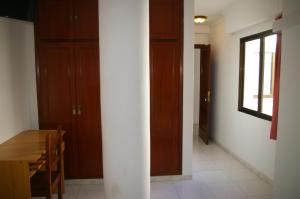 una habitación con una mesa y algunas puertas de madera en Habitación doble Puerta de Almenara - Alquiler de temporada, en Puerto Sagunto