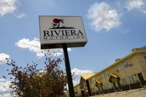 Riviera Motor Inn في ساسكاتون: علامة لنزل السيارات أمام المبنى