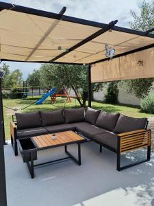 a couch and a table under a wooden canopy at Villa Marta in Murvica