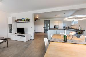a kitchen and living room with a dining room and a table at Schmuckstück in Hilzingen +15 photos