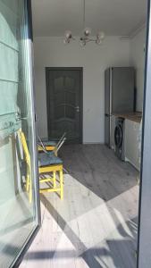 a kitchen with a yellow chair and a refrigerator at La Ana Apartament in Şelimbăr