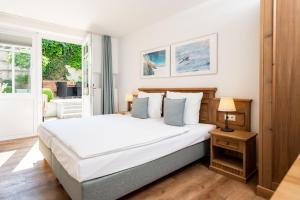 a bedroom with a large white bed and a window at Apartments an Sankt Marien in Stralsund