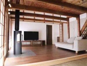 龟冈Kiri no Kōbō Private Lodge with Goemon Bath的配有沙发和平板电视的客厅