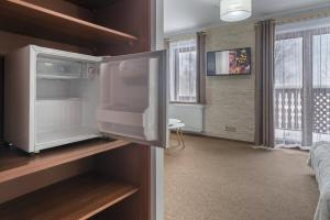 a room with a refrigerator in a bedroom at Nefryt - 600 m od PKP, duży parking, lodówka, czajnik, balkon, in Karpacz