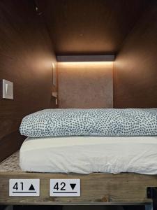 a bedroom with a bed with two signs on it at Solo Stay Myeongdong in Seoul