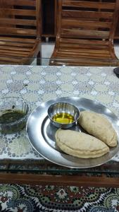 two breads on a plate with a bowl of mustard at Craignano Homestay & Family suite rooms in Shimla