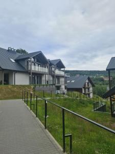 a row of houses on a hill with a walkway at Apartamenty Czarne Owce in Szklarska Poręba