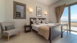 a bedroom with a bed and a chair and a mirror at Villa Robola in Mavráta +33 photos