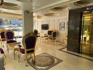 une chambre avec des chaises, une table et une télévision dans l'établissement Napolyon hotel, à Istanbul
