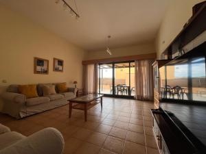 salon z kanapą i stołem w obiekcie La Casa del Sol ll by Best Holidays Fuerteventura w Corralejo