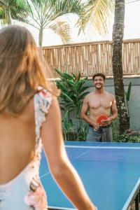 a man holding a frisbee in front of a table at The Palms Canggu in Canggu