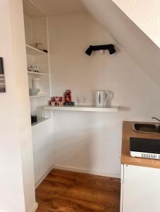 a kitchen with white walls and white shelves at Room Deluxe in Meerbusch +2 photos