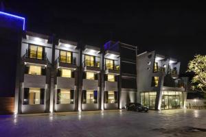 a lit up building with a car parked in front of it at M Hotel in Caotun