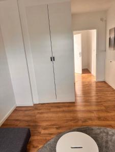 a living room with a white closet and a wooden floor at Room Deluxe in Meerbusch
