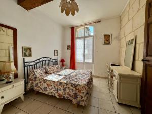 a bedroom with a bed and a window at Le Doyenné, hotel particulier centre ancien de Tarascon in Tarascon