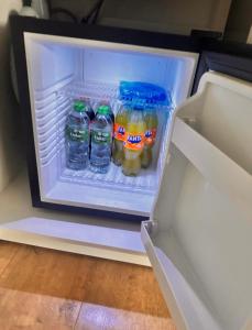 a refrigerator filled with bottles of water and fruit at Room Deluxe in Meerbusch