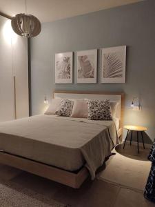 a bedroom with a bed with four pictures on the wall at Salita al castello in Rossana