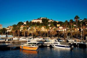 Un grupo de barcos atracados en un puerto deportivo con casas. en L'appartement Lavande, en Le Lavandou
