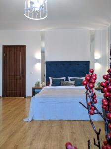 a bedroom with a large bed with a blue headboard at Best Apartment in the Center in Mukacheve