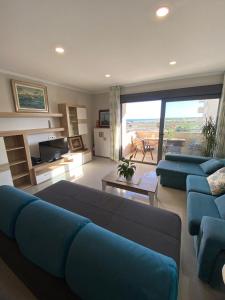 a large living room with blue couches and a large window at LA MARINA in Torre del Mar