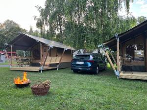 a truck parked in a yard with a tent and a fire at Delta Glamping in Balatonederics +11 photos