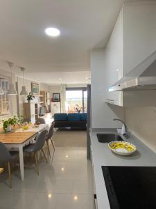 a kitchen and living room with a table and a counter top at LA MARINA in Torre del Mar