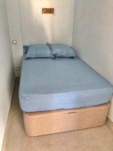 Una cama en una habitación pequeña con un colchón azul. en Le Regina Studio 5p mer parking, en Le Grau-du-Roi