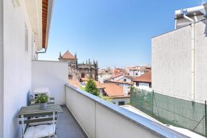 a balcony with a table and a view of a city at Ao Pé da Sé next to Braga Cathedral By Sé Apartamentos in Braga