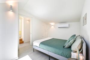 a bedroom with a bed in a white room at Ao Pé da Sé next to Braga Cathedral By Sé Apartamentos in Braga