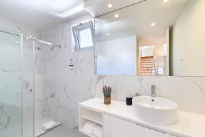 a white bathroom with a sink and a shower at Ao Pé da Sé next to Braga Cathedral By Sé Apartamentos in Braga +15 photos