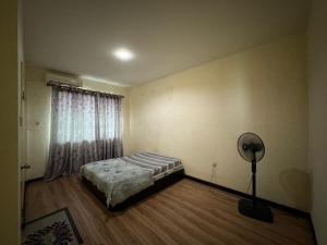 a bedroom with a bed and a fan in it at Little Pearl Homestay in Bintulu