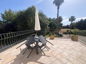 two chairs and an umbrella on a patio at Villa Madama Depandance in Galatina +4 photos