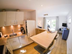 a kitchen with a wooden table and a counter top at friesen-nest-spo in Böhl