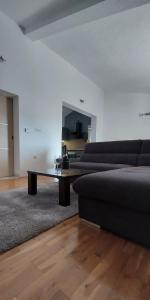 a living room with a couch and a glass table at I&A apartman in Kaštela