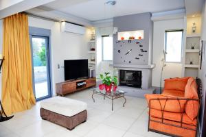 a living room with a fireplace and a clock on the wall at Diamond Rod Villa near Faliraki in Kalithies