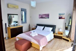 a bedroom with a large bed and a mirror at Diamond Rod Villa near Faliraki in Kalithies