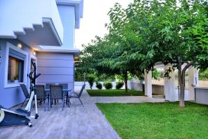KalithiesにあるDiamond Rod Villa near Falirakiの家の隣のパティオ(テーブル、椅子付)