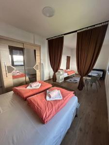 a bedroom with a large bed with red sheets at Appartement UNA La Bella 3* in Bihać