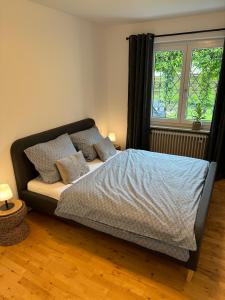 a bedroom with a bed with pillows and a window at Wohnung mit Garten am See in Langenargen