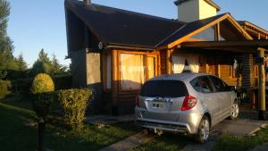 a car parked in front of a house at Ensueño Cabañas in Los Reartes