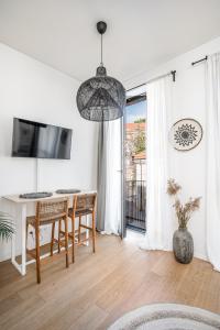 a white living room with a table and chairs at Bali style apartment with balcony near Gates of Dawn in Vilnius