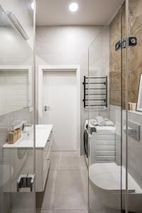 a bathroom with a sink and a washing machine at Bali style apartment with balcony near Gates of Dawn in Vilnius +32 photos
