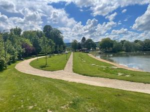 a winding path in a park next to a lake at Chez Coccinelle in Marmagne