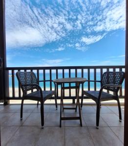 a table and chairs on a balcony with a view of the ocean at Akrogiali in Agios Ioannis Pelio