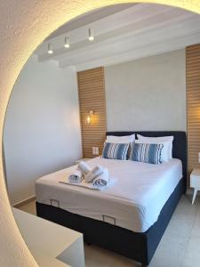 a bedroom with a large bed with a mirror at Akrogiali in Agios Ioannis Pelio