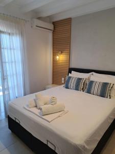a bedroom with a large bed with towels on it at Akrogiali in Agios Ioannis Pelio