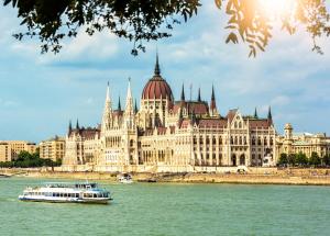 a boat in the water in front of a large building at Verdi Budapest Aquincum in Budapest