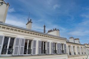 a white building with white shutters on it at Hotel de la Paix Tour Eiffel in Paris
